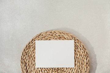 Wall Mural - Blank paper sheet with mockup copy space, straw stand on concrete background. Flat lay, top view minimal social media template.