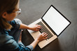 © Serhii - Beautiful happy young woman working and using white blank screen laptop computer in the bedroom. Freelancer. Writing, typing. Girl in social apps. Communication and technology concept. Top view.
