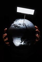 Wall Mural - hands of child hold globe on black background