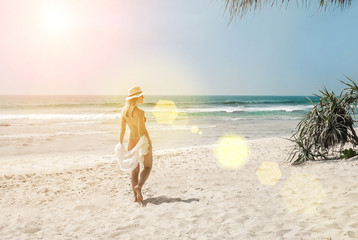 Happy traveller woman in white enjoys her tropical beach vacatio