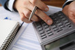 © megaflopp - Man analyzes cost renting, counting on calculator