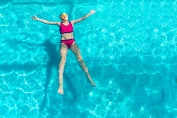 girl swims in a blue pool