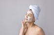 © Mountains Hunter - Beauty portrait of woman in white towel on head applies cream to the face. Skincare cleansing eco organic cosmetic spa relax concept.
