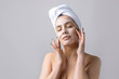 © Mountains Hunter - Beauty portrait of woman in white towel on head applies cream to the face. Skincare cleansing eco organic cosmetic spa relax concept.