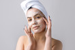 © Mountains Hunter - Beauty portrait of woman in white towel on head applies cream to the face. Skincare cleansing eco organic cosmetic spa relax concept.