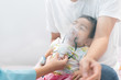 Close up of asian little baby boy is treated respiratory problem with vapor nebulizer to relief cough symptom in the hospital room , concept of covid-19 outbreak and pm 2.5 effect to child health.