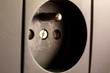 © Joeri - A close up portrait of a type E wall socket used to supply electric or electronic devices from power. It has two holes and a earthing or grounding. It supports type E and F plugs.