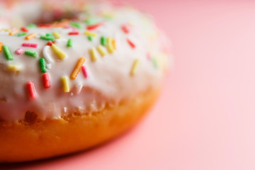 
Two juicy fresh sweet donuts with sugar icing and sprinkles on a pink background