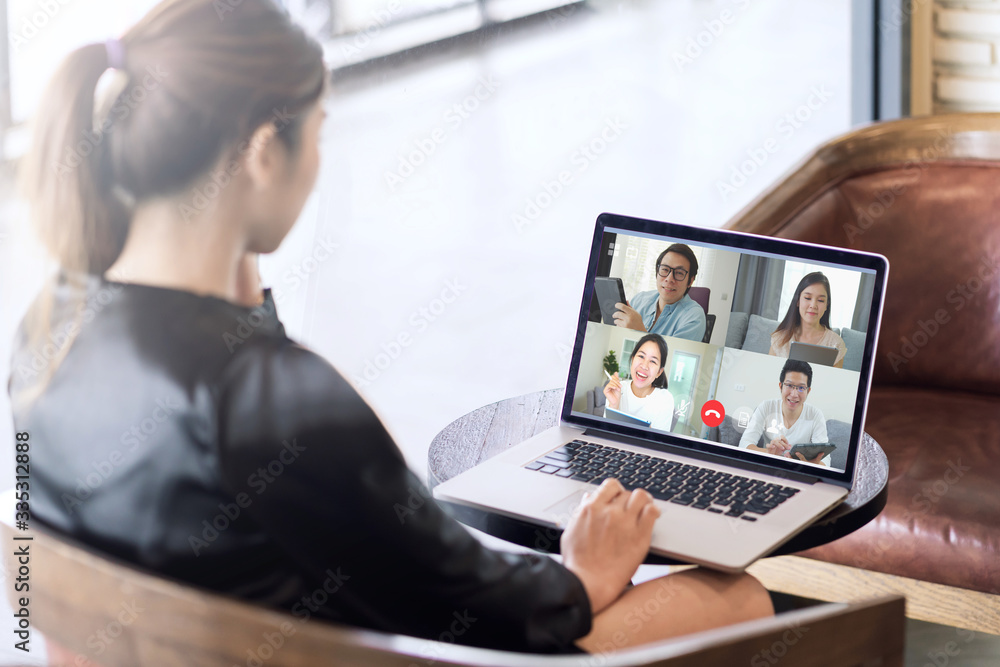 Back view of business woman talking about sale report in video conference. Asian team using laptop and tablet online meeting in video call.Working from home, Working remotely and Social isolation. - obrazy, fototapety, plakaty 