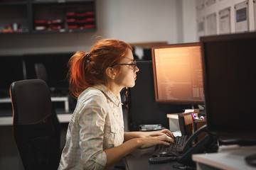 female programmer working working late at night in her office.