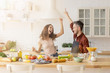 © deniskomarov - Happy married couple having fun at home kitchen.