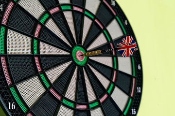 Close-up of a dart arrow with the English flag in the center of the dart board to represent that the company or the country achieved the company's objective. Objective and goal as a concept.