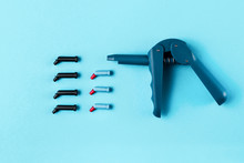 Composite Syringe Gun With Tubes And Plugs. Autoclavable Plastic Handle With Pistol Grip Design