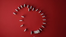 Domino Effect. Dominoes Falling In Slow Motion Video On A Red Background. Circle Of Dominoes. Coronavirus Pandemic Concept