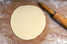 Rolled Dough On A Wooden Board Sprinkled With Flour And Rolling Pin, Pizza Dough Or