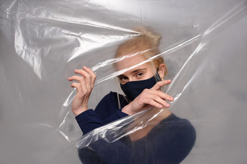 Wall Mural - Quarantined woman wears a protective mask.
Quarantined woman breakthrough of oilcloth.