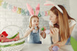 © hetmanstock2 - Mother and daughter paint eggs. Family in a kitchen. Preparing for Easter