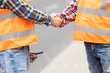 Two builder shaking hand on the road construction field