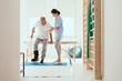 © Photographee.eu - Young physiotherapist exercises in a bright medical office with his injured patient
