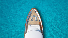 Aerial Drone Top Down Photo Of Luxury Exotic Yacht Nose With Wooden Deck Anchored In Paradise Turquoise Bay