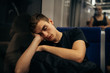 © eldarnurkovic - Passenger sitting in the seat and sleeping inside a train/bus while traveling.Tired exhausted looking young man getting away with train ride.Going home from work.Bored person during commute time.Nap