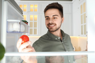 Sticker - Young man looking into refrigerator, view from inside