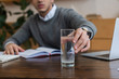 © LIGHTFIELD STUDIOS - Cropped view of businessman taking glass of water in office