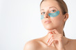 © Olesia - Cosmetology, skin care, face treatment, spa and self-care at home concept. Woman with eye gel pads mask.
