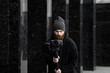 © Volodymyr_sh - Bearded Professional videographer in black hoodie holding professional camera on 3-axis gimbal stabilizer. Filmmaker making a great video with a professional cinema camera. Cinematographer.