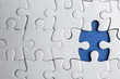 © New Africa - White puzzle with missing piece on blue background, top view. Career promotion concept