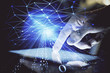 © peshkova - Double exposure of man's hand holding and using a digital device and data theme hologram drawing. Technology concept.