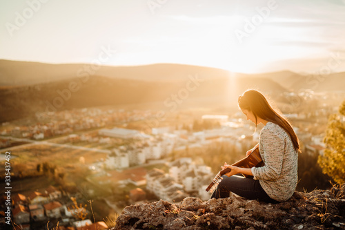 Fotomural Young guitarist playing acoustic guitar and enoying the sunset