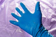 © lucky pics - used blue protective glove with perforating hole on the inside of the palm