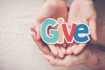 Adult and child hands holding Give word, kind, donate, charity and compassion concept