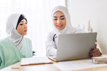 Wall Mural - Muslim asian female doctor consulting and check up information on laptop computer with muslim woman in hospital.woman has sick.healthcare and medicine