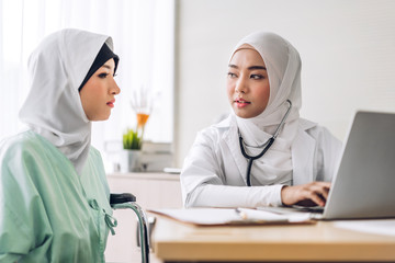 Wall Mural - Muslim asian female doctor consulting and check up information on laptop computer with muslim woman in hospital.woman has sick.healthcare and medicine