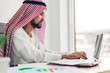 © Art_Photo - Handsome confident arab businessman working and looking at technology of laptop computer monitor.Creative coworkers arabic business people thinking and planning at modern work loft