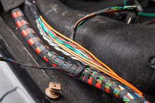 Large Wide Cable With Multicolored Orange And Green Wires, Connectors And Terminals In The Wiring Repair Shop And Electricians For Connecting And Transmitting Electricity And Digital Signal In The Car