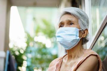 Senior woman wearing face mask during corona virus and flu outbreak. Disease and illness protection.