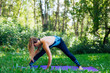 © Smile - Young woman doing yoga exercises in summer city park.