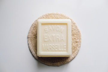 Squared marseille soap bar on a loofah.