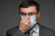 © soleg - a man puts a mask on his face for antivirus individual protection - healthcare and medicine concept, prevention tips
