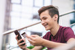 © Valua Vitaly - Teenage boy with a credit card and mobile phone makes purchasing outdoors. Happy young man is using smartphone and bank card for online shopping. Handsome smiling guy holds bank card and cell phone