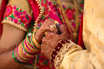 Traditional indian wedding ceremony, groom holding hand in bride hand