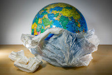 Plastic With Earth Inside And Some Trash. Earth Is Being Destroyed Because Of Too Much Garbage Like Plastic