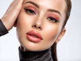 Portrait of beautiful young woman with bright pink makeup. Beautiful brunette with bright orange lipstick on her lips.
