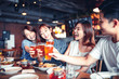 © Tom Wang - happy young group dining and drinking beer at restaurant