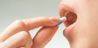 © Alex Photo - Woman taking a medical capsule, close-up of mouth.