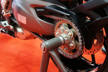 Motorcycle chain. It is a metallic chain that is used to transmit power from the engine to the rear wheel.