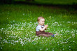 © Elena  - Charming boy among green grass and beautiful daisies on a summer day. A small child has fun in the fresh air. Baby explores the nature of
